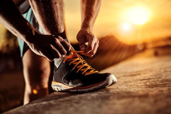 Homme qui lasse sa chaussure pour une séance de sport